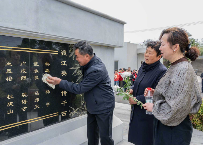 韩连增烈士的外甥周锡余擦拭墓碑上舅舅的名字