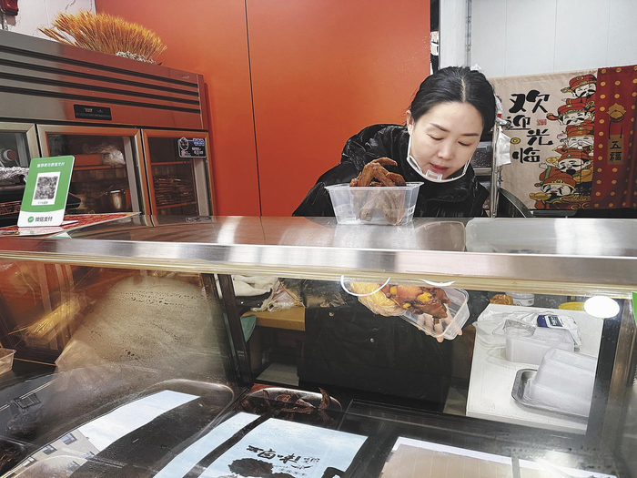 李海青正忙着自家卤肉铺的生意。 本报记者 王臻 摄