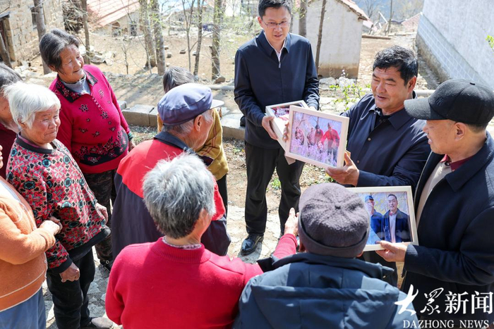 淹子岭村党支部书记国成勤将打印好的照片分给大家。
