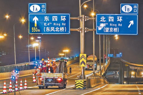 昨天凌晨，北京四环四元立交桥系混凝土铺装层翻建修复工程启动，施工人员在匝道施工区域外围进行封路导流。本报记者 邓伟摄