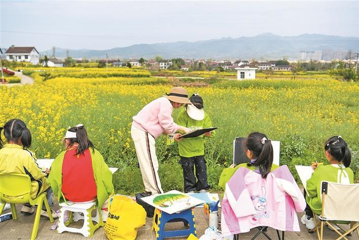     3月28日，学生在陕西省汉中市西乡县杨河镇高土坝社区油菜花观花点研学。    新华社记者  邹竞一  摄
