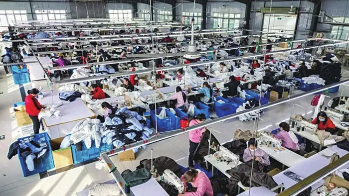 丽探越制衣车间内，在各类缝纫机械嗡鸣声中，工人们专注地裁剪、缝制、熨烫。绮丽探月供图