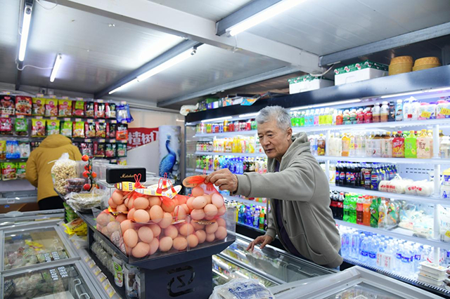 刘晓明老人在小区内的便民超市购买东西。邵南摄
