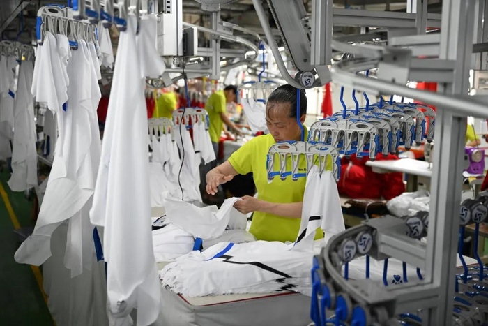 晋江卡尔美体育用品有限公司服装生产车间，工人在赶制订单/