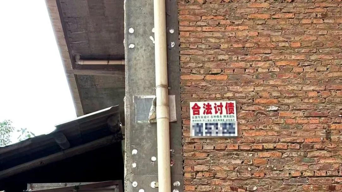 陈埭镇的巷子里，墙角上贴着“合法讨债”的小广告/盐财经施晶晶 摄