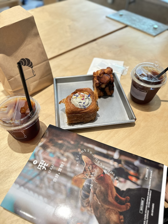 一家广州城市里的特色咖啡店内，店主与食客分享宠物主题杂志。张佐仪 摄