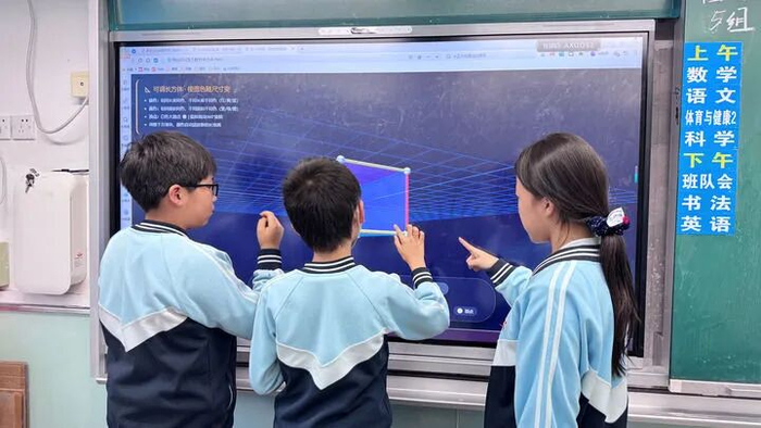 北京市西城区奋斗小学学生在体验教师借助人工智能工具生成的三维立方体模型。受访者供图
