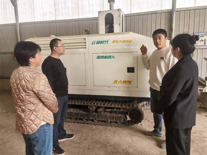 图为玉田县纪检监察干部联合县农业农村局技术人员走访农机合作社，了解灌溉机器人使用情况。