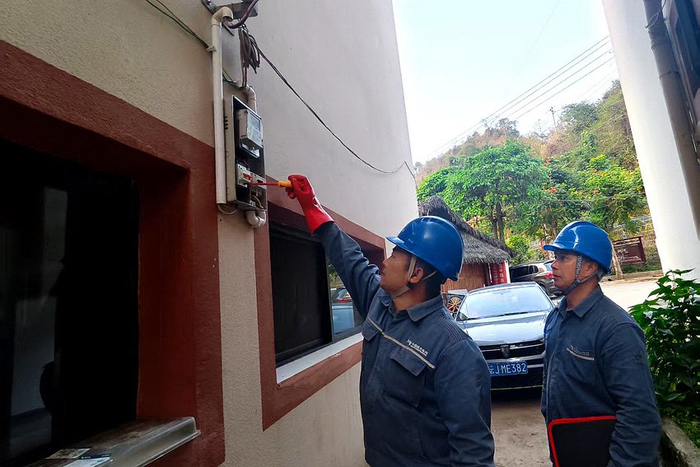 金平供电局金水河供电所工作人员为隔界村用户开展安全用电检查。龙波摄