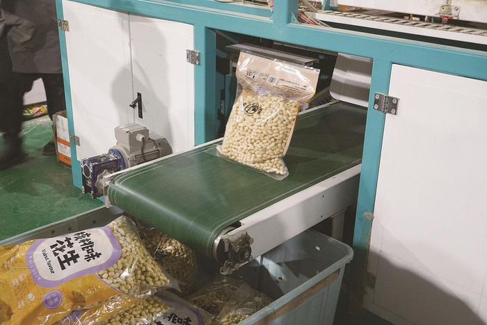     图为铁局寨村的炒货厂正在打包炒熟的花生。                 郭一凡 摄