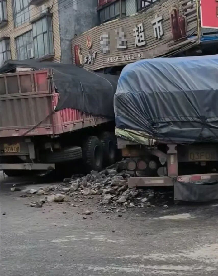 △两辆货车直冲超市，现场散落建筑碎石。