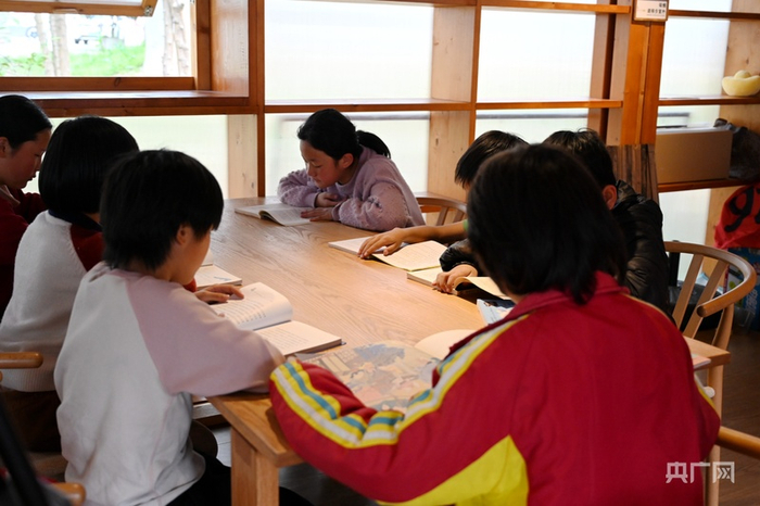 孩子们沉浸在书香之中，认真翻阅书籍（央广网发  李悭  摄）