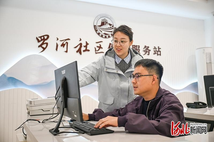 4月17日，李泽（左）与工作人员一起讨论社区治理方案。 河北日报记者 李东宇摄