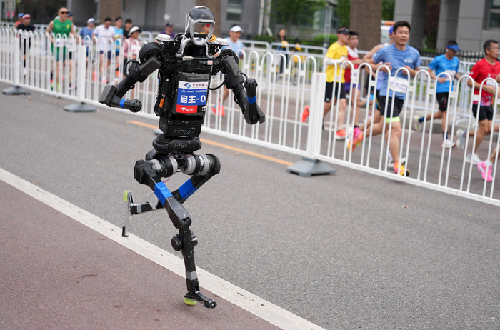 4月19日，杭U赛队自主人形机器人选手宇树H1（前）在比赛中。新华社记者 雒圆 摄