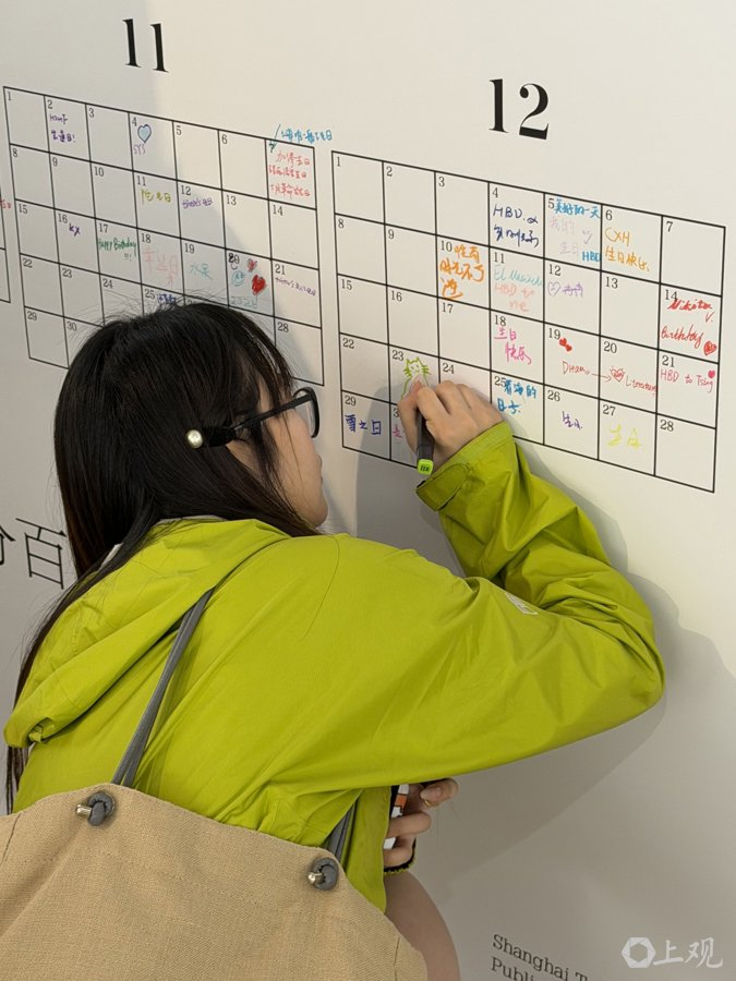 在“百分百日历墙”上涂涂画画的读者。施晨露摄