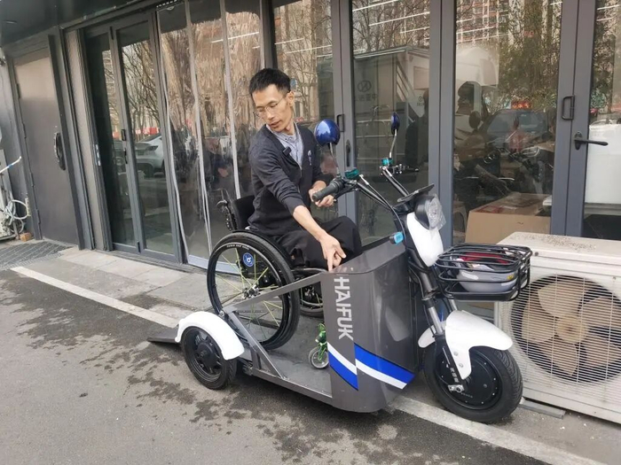 于文涛向记者展示子母轮椅车驾乘方式