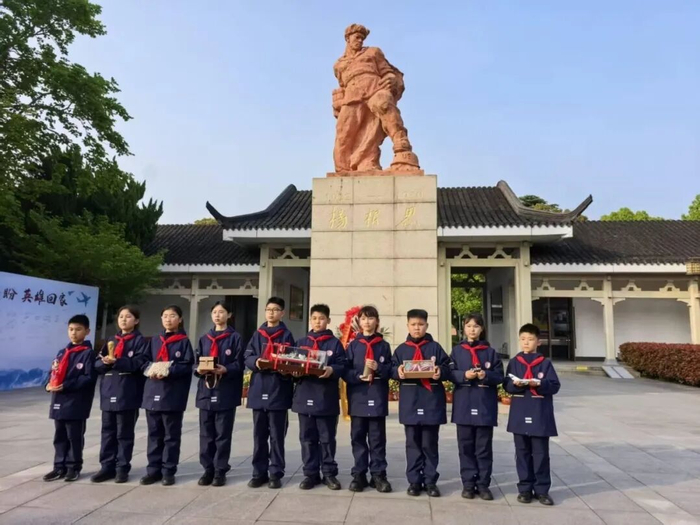 出发前，孩子们手捧礼物在泰兴杨根思烈士陵园留影