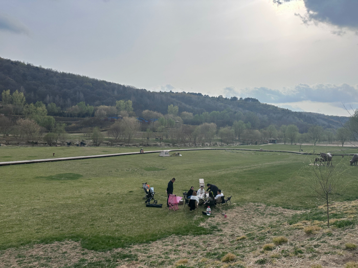 外地游客在草地上露营，拍摄于2026年4月。