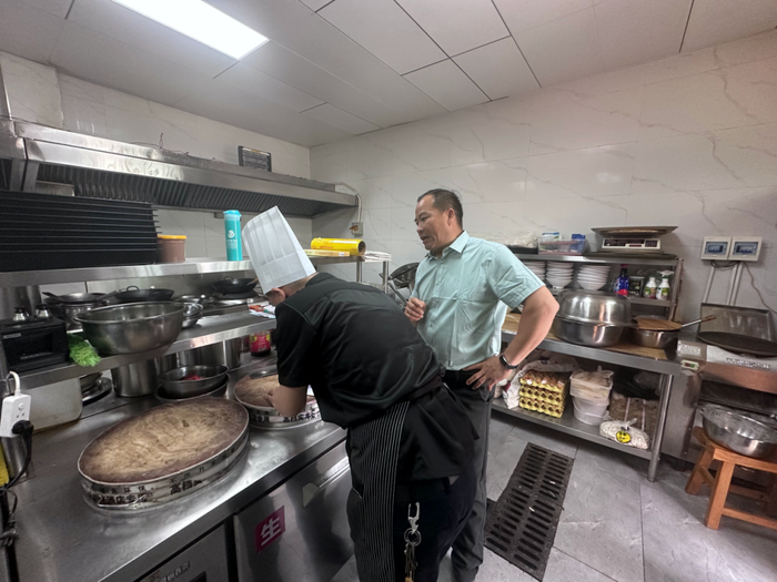 杜方飞（右）在和厨师沟通游客的配菜。