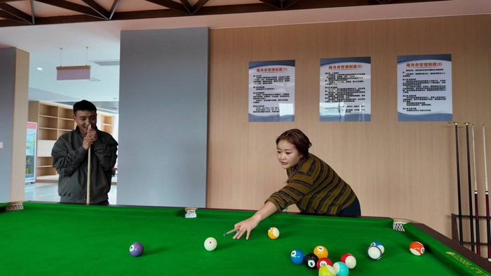 巴桑和扎西旦增在员工休闲区打台球。