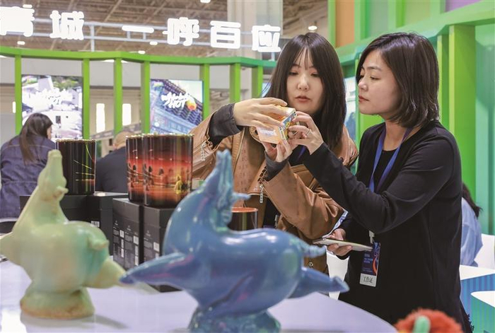 参展商在呼和浩特展区了解文创产品                               ■本报记者 王劭凯 摄