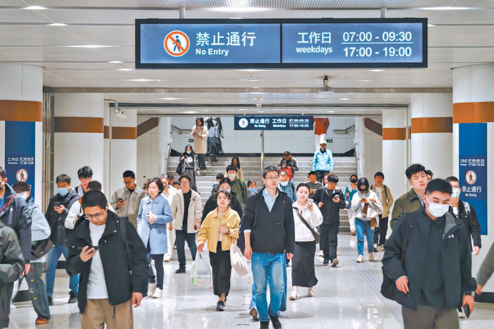 地铁蓟门桥站换乘通道已挂出通行时间提示，非高峰时段支持乘客双向换乘。 本报记者 邓伟摄