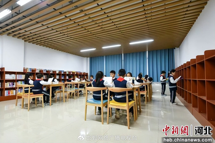 图为师生正在阅览室共同阅读。 白雪 摄