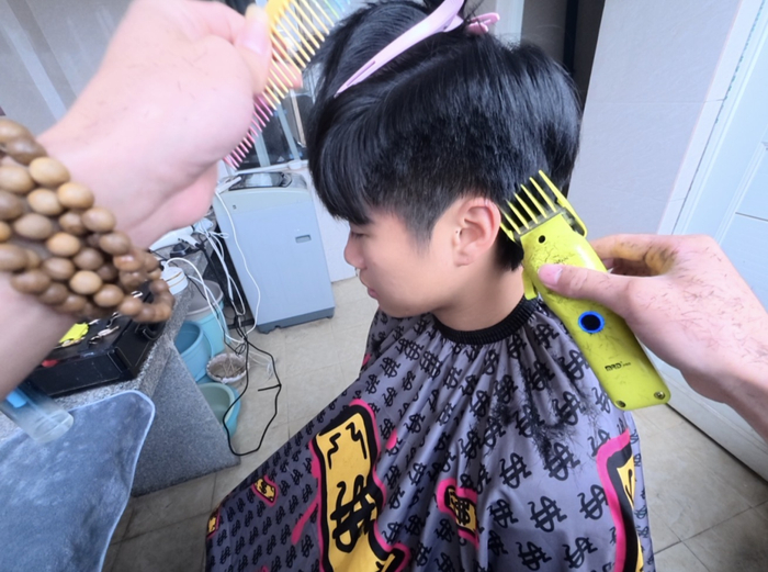 “小么同学”正在宿舍帮客人理发