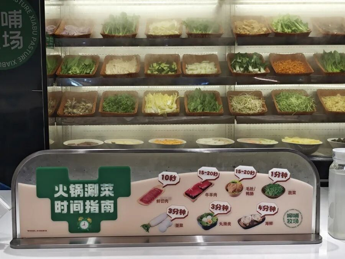 呷哺牧场，桌上有避免与人对视尴尬的围挡，还有涮菜指南。吴越摄