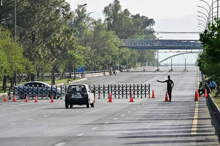 △当地时间4月25日，巴基斯坦伊斯兰堡，一名安全人员在红区封闭道路处疏导交通