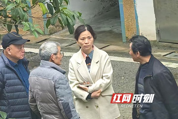 社区工作人员在现场了解加装电梯的情况。