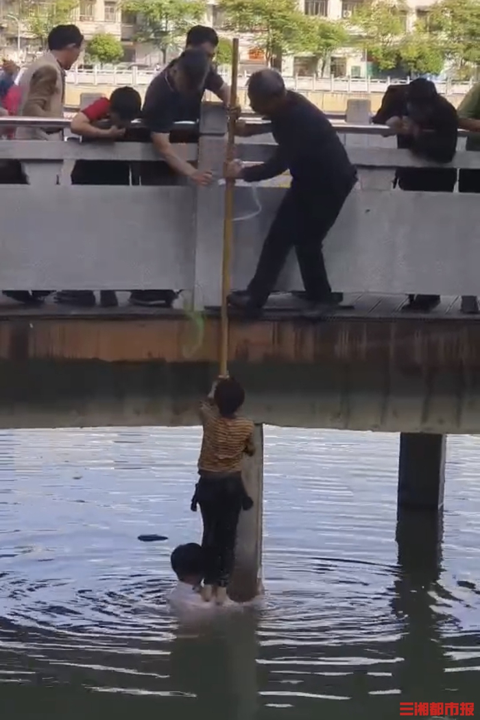   （资小明跃入水中救起落水男童。受访者供图）