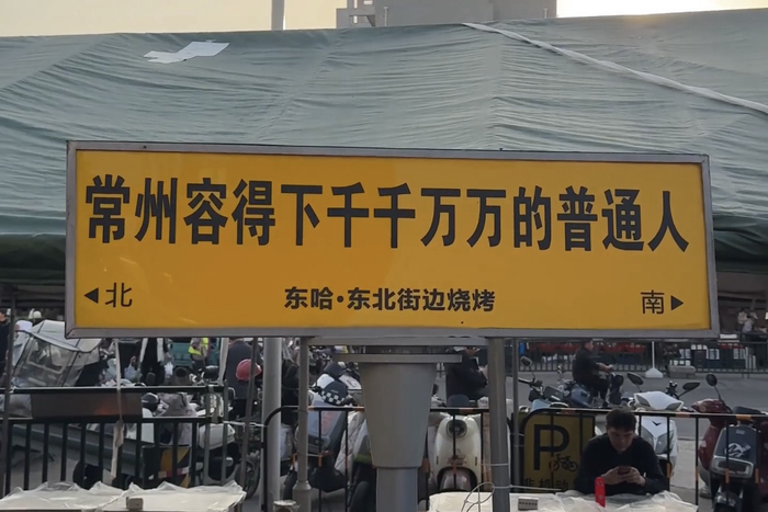 东哈·东北街边烧烤门口标语。（光明网记者 王文韬摄）