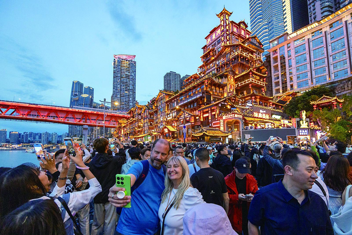     外籍游客在重庆市渝中区洪崖洞景区前自拍