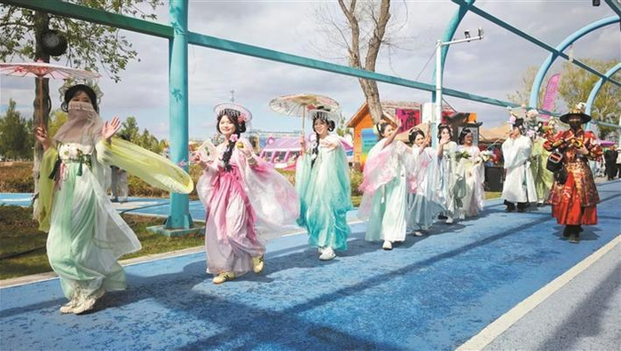     4月19日，在六师五家渠市第二十一届郁金香文化旅游节上，巡游古装扮演者与游客零距离互动。杜仪  朱小丽  摄