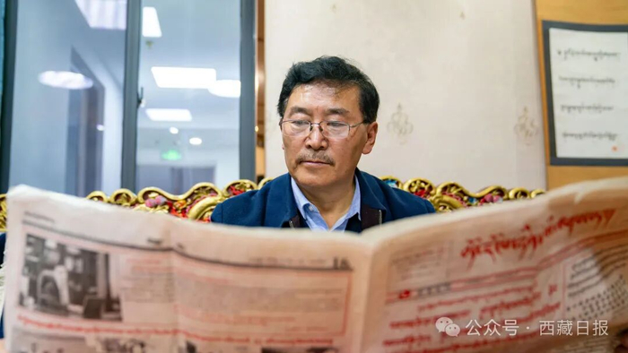 图为2026年4月3日，扎西班典接受西藏日报社“老报人说”采访组采访时，翻阅以前参与编辑发布的《西藏日报》藏文版。