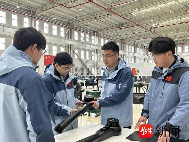 李恒（右二）带着同事们一起研究组装部件。任国勇 摄