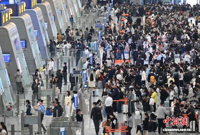 4月30日，大量旅客在杭州东站准备检票登车。当日，浙江杭州迎“五一”假期前铁路客流高峰。中新社记者 王刚 摄