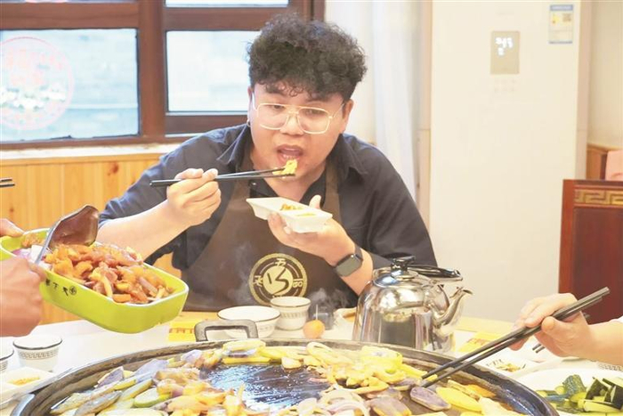 游客品尝烙锅。贵州日报天眼新闻记者 李佳琪 摄