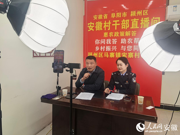 李振雷（左）在直播间进行政策宣讲。人民网记者 陈若天摄