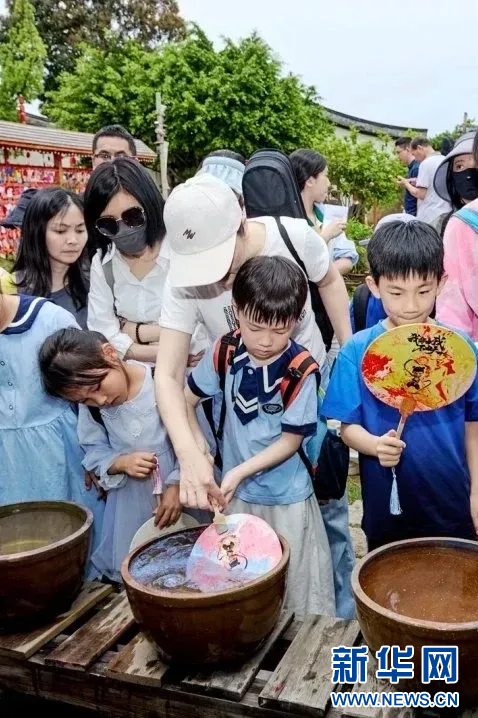 游客在梁厝特色历史文化街区体验非遗项目。新华网发（福州名城保护开发有限公司供图）