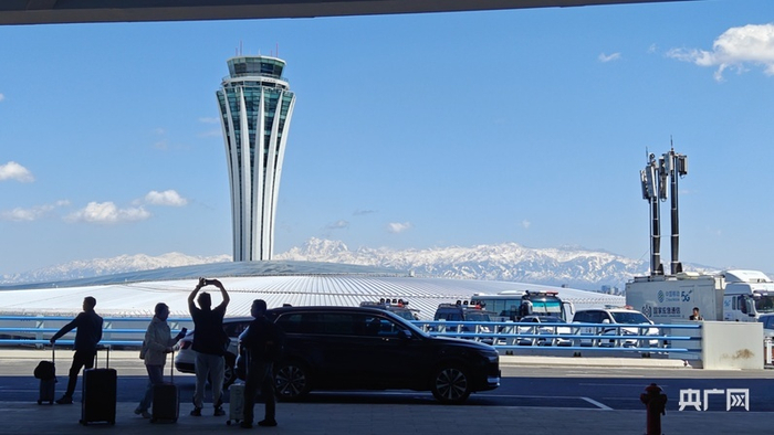 旅客在北航站区新航站楼前拍照留念  （央广网记者  郭璁悦  摄）