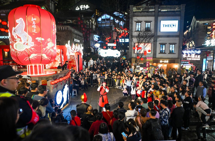 2月20日，游客在重庆十八梯传统风貌区观看节目表演。新华社记者唐奕 摄