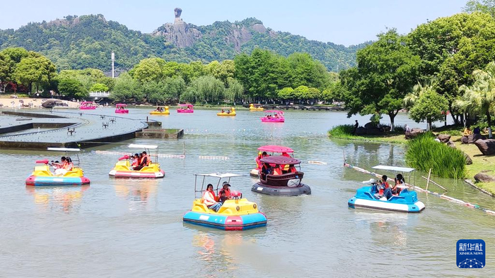 5月1日，在浙江省温岭市锦屏公园，家长带着孩子体验水上游乐项目。新华社发（郑玲富摄）