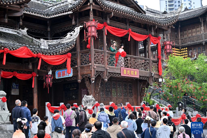 5月1日，游客在湖北省恩施土家族苗族自治州宣恩县城兴隆老街体验土家婚俗。新华社发（宋文摄）