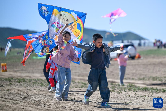 5月1日，小朋友在新疆乌鲁木齐市水磨沟区石人子沟放风筝。新华社记者 丁磊 摄