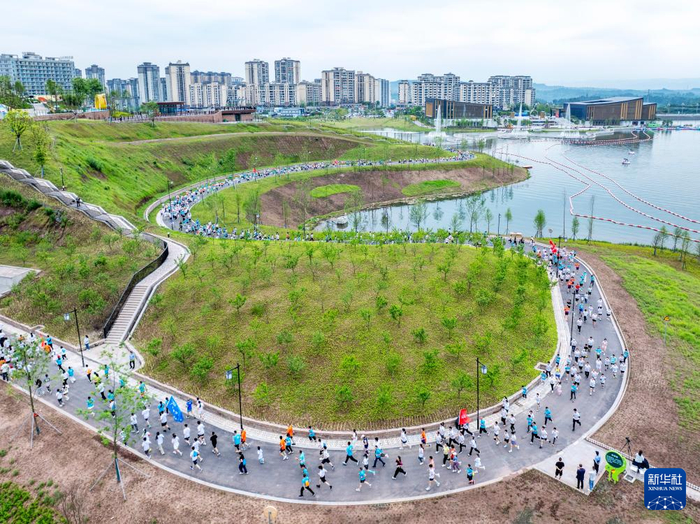 5月1日，跑手在四川省广安市广安区官盛湖公园环湖绿道上奔跑（无人机照片）。新华社发（张国盛摄）