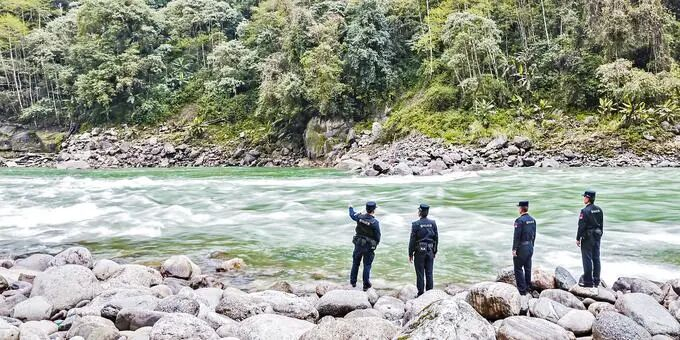 4月15日，云南怒江独龙江边境派出所民警辅警在独龙江畔巡查。（陈路坤 摄）