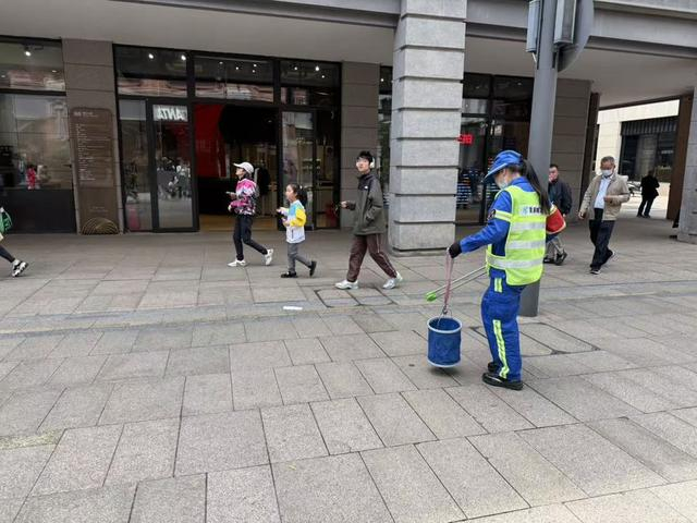 南京路步行街上的环卫人员即时清理路面上的垃圾。沈思怡 摄