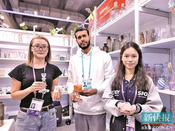 ■华南农业大学英语专业的谭同学（右一）在展位向外国客商介绍产品。 受访者供图